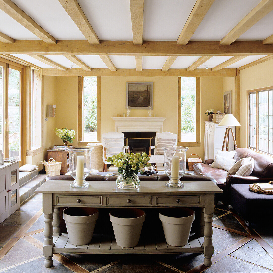 Living room with fireplace, wooden beamed ceiling and light yellow walls