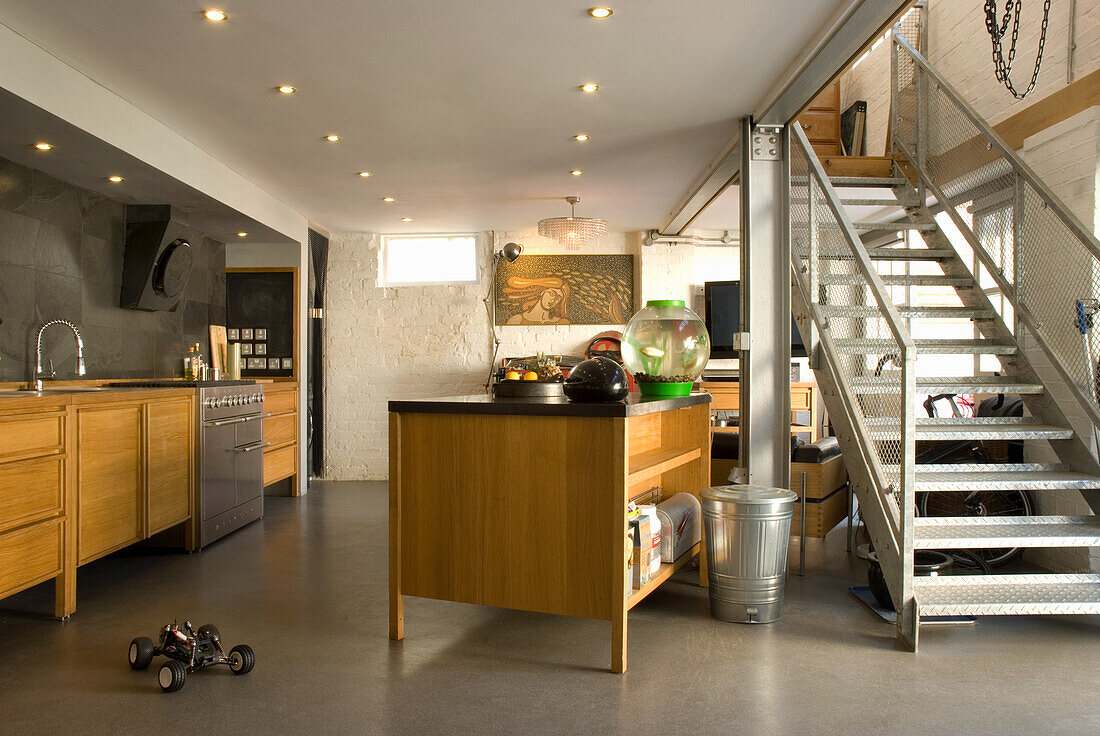 Loft-style kitchen with cooking island and metal staircase