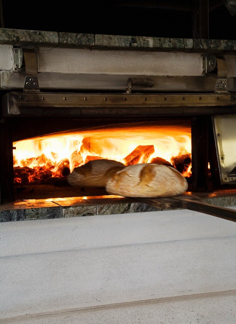 Bread being removed from a wood-fired oven