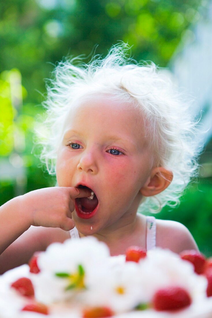 A little girl eating cake