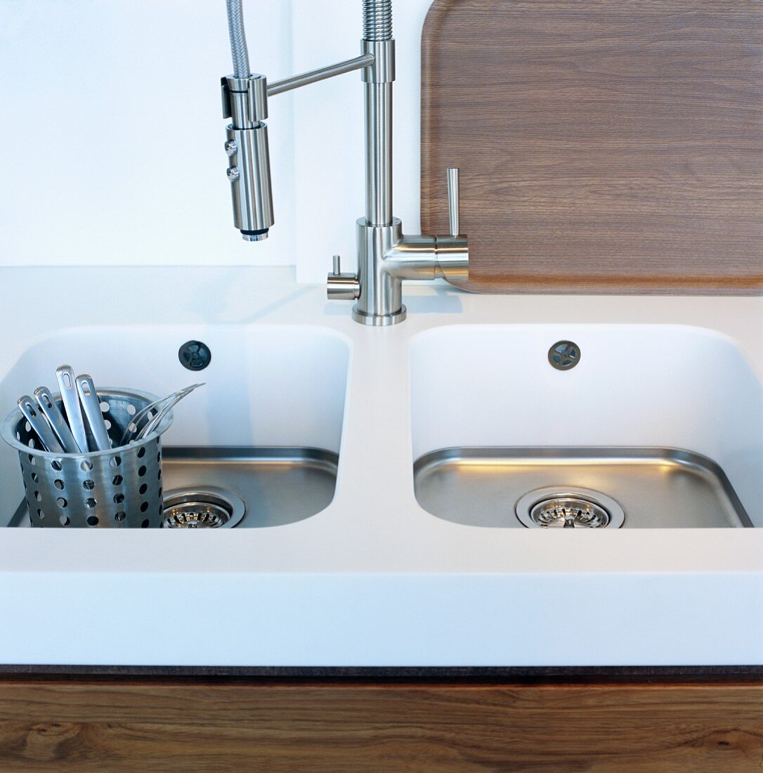 A basket of cutlery in sink