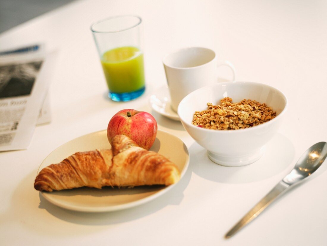 Frühstück mit Cerealien, Croissant, Apfel und Orangensaft