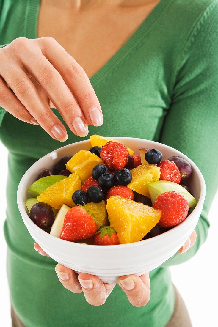 A woman eating fruit salad