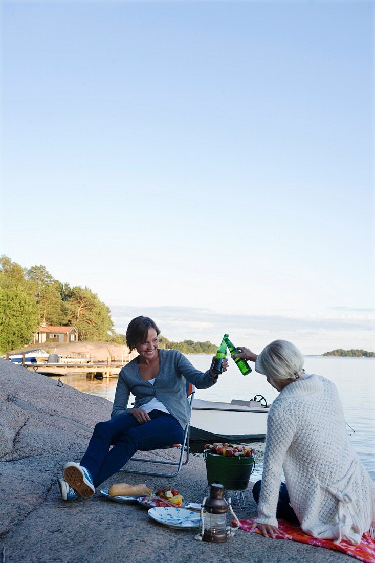 Two women having a picnic by the sea in Stockholm (Sweden)