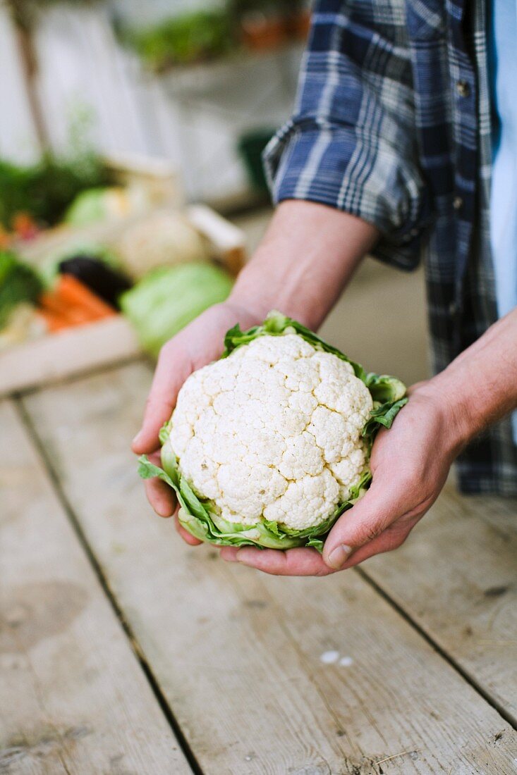 A person holding a cauliflower