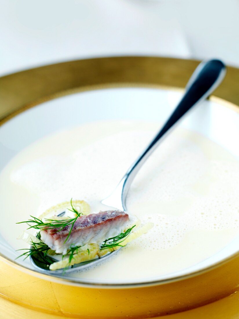 Fish soup with pieces of fish on a spoon