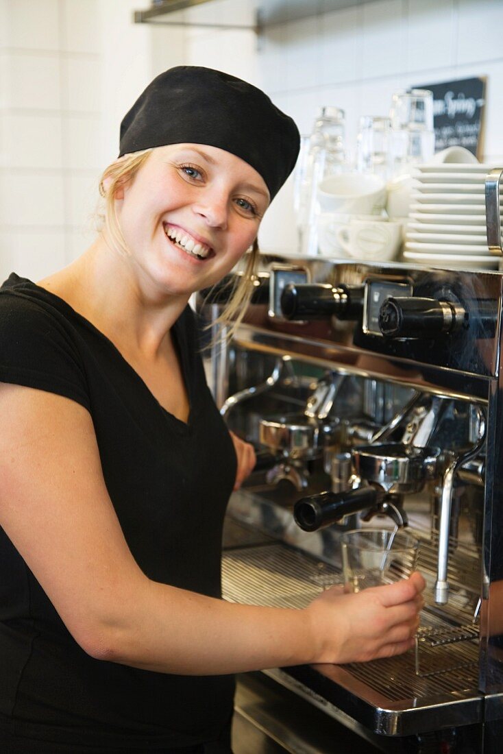 Kellnerin bereitet Kaffee zu im Lokal