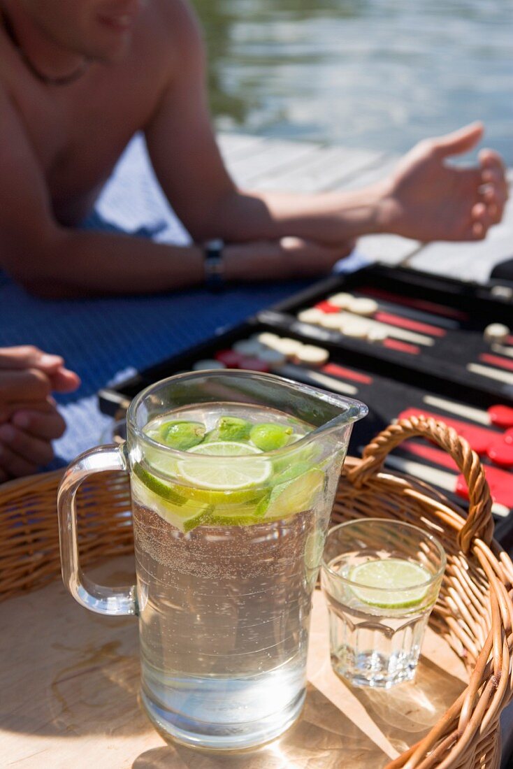 Young people on a jetty with a backgammon game and lemonade