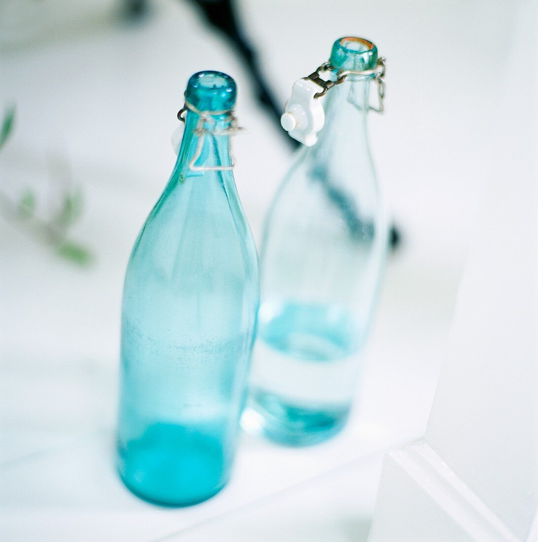 Leere Flasche und halbvolle Wasserflasche