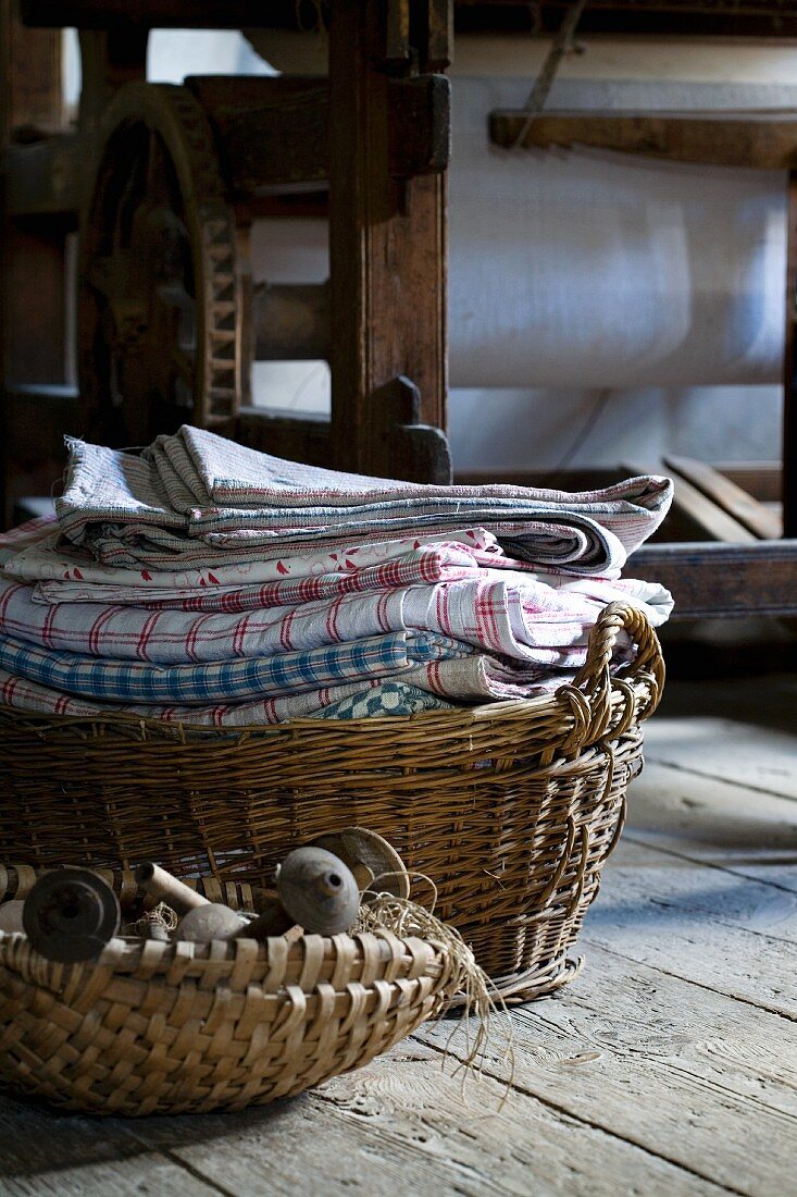 Basket of old objects in front of basket of laundry on floor