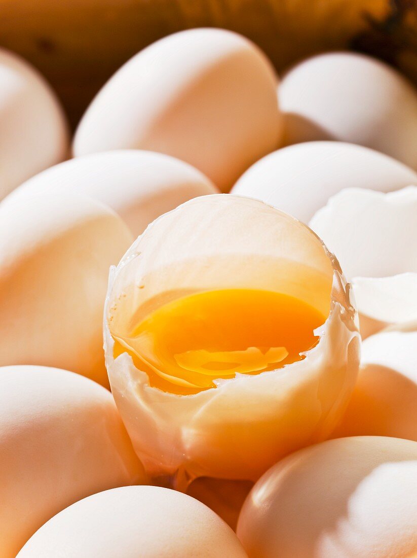 Ganze Eier und ein aufgeschlagenes rohes Ei