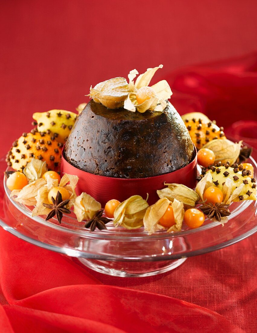 Christmas pudding with cape gooseberries on red cloth