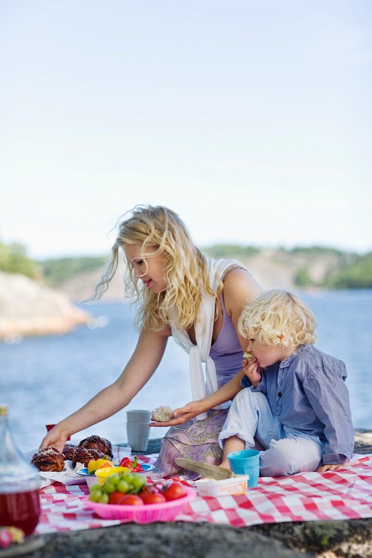 Mutter und Sohn beim Picknick am See