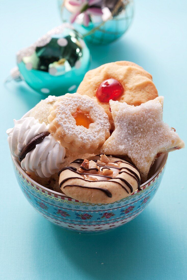 Various Christmas biscuits in a floral bowl
