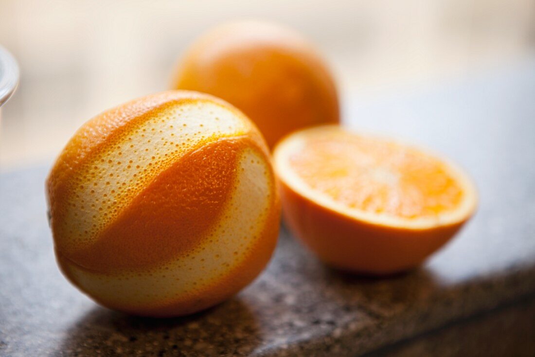 Orangen, halbiert und teilweise geschält