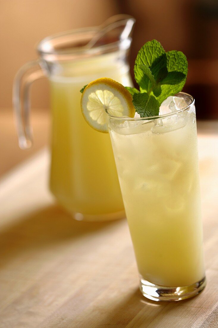 Glass of Lemonade with Lemon and Mint Garnish; Pitcher of Lemonade