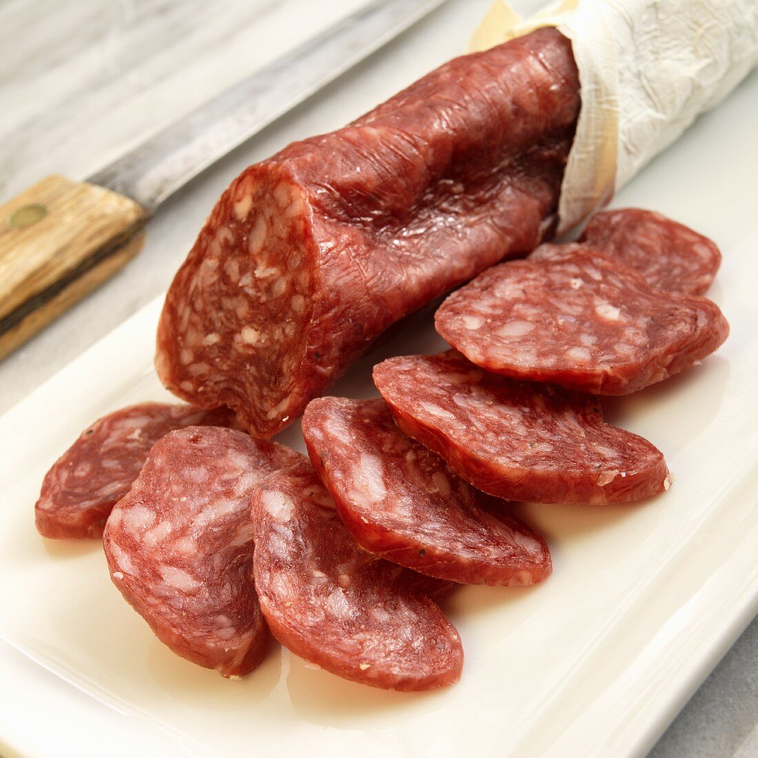 Salchichon De Vic; Catalonian Style Dry Salami; Sliced on Cutting Board