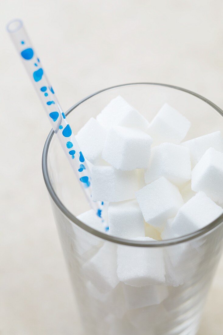 Glass Full of Sugar Cubes with a Straw