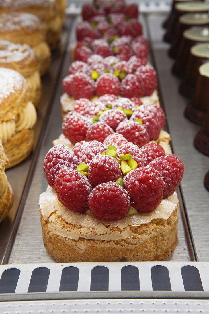 Raspberry Montebello Tarts with Pistachio Dacquoise and Pistachio Mousseline in Bakery Display Case