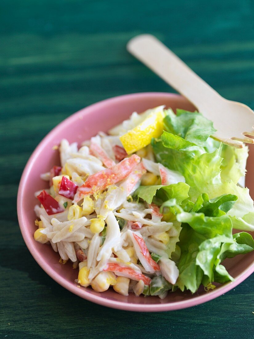Orzo-Salat mit Krebsfleisch, serviert mit Blattsalat