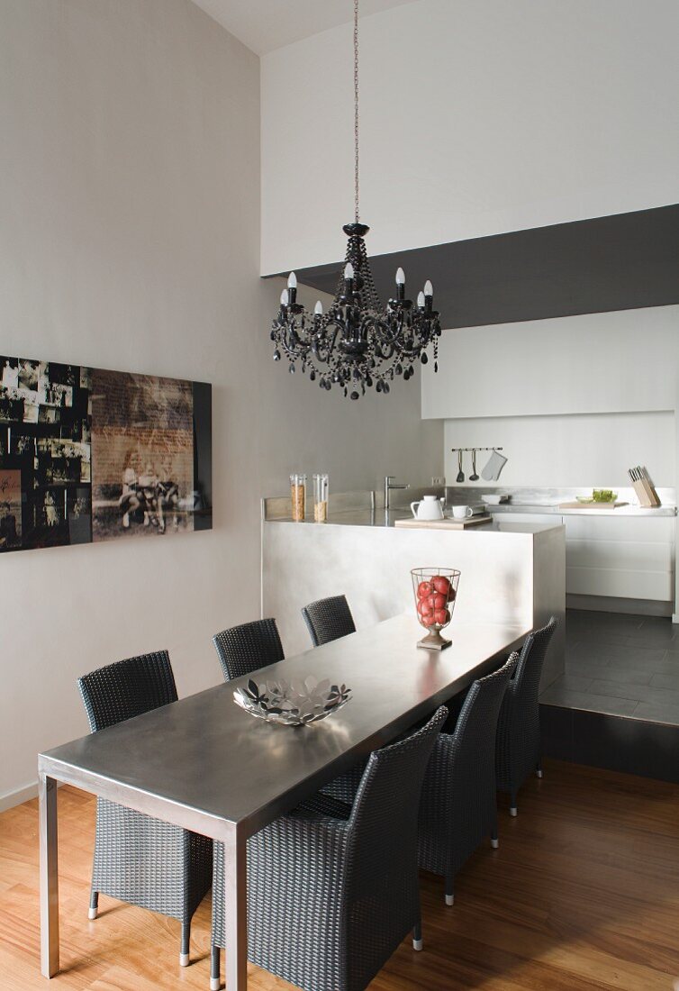 Esstisch mit Korbsesseln aus grauem Rattan in moderner Küche
