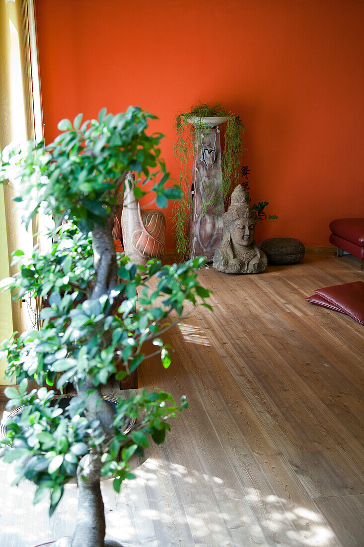 Asian-inspired corner with Buddha head and houseplant