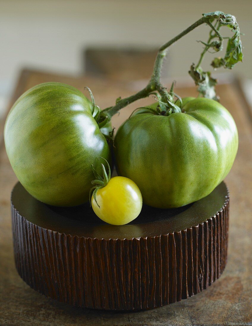 Eine gelbe und zwei grünen Heirloom Tomaten