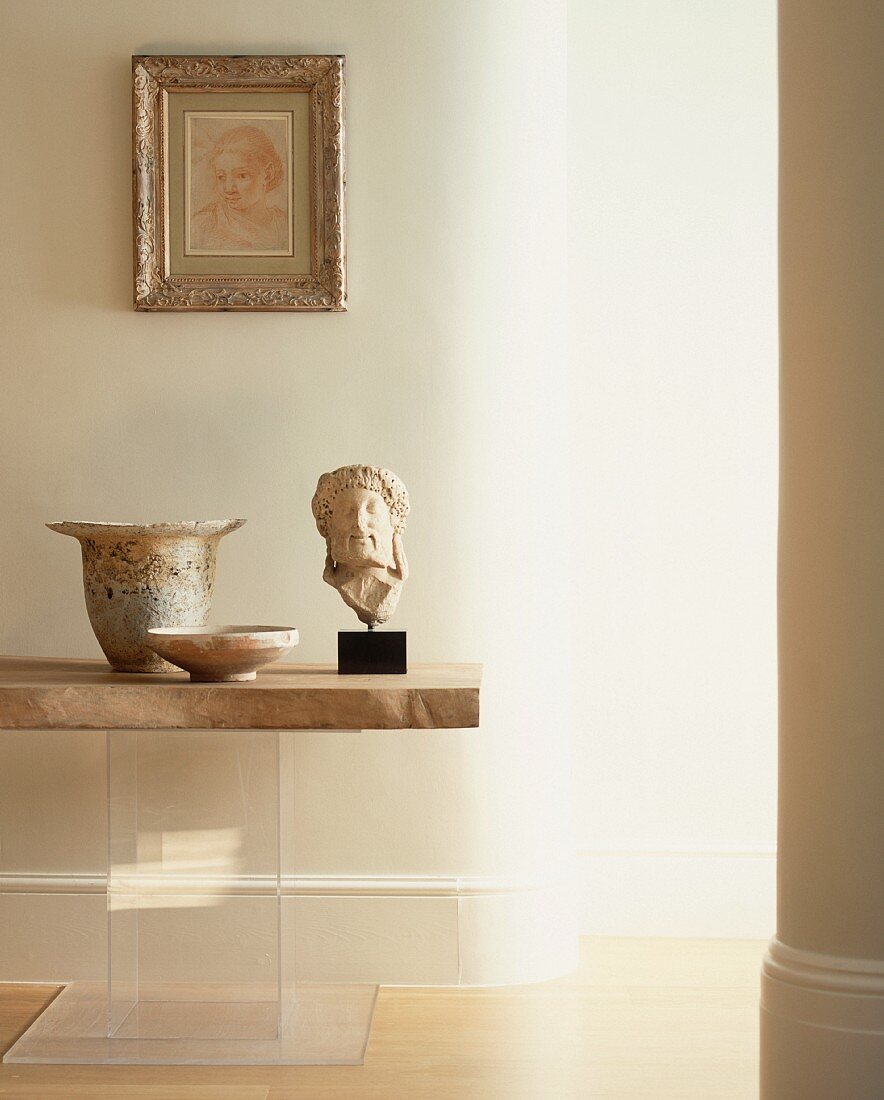 Antique Greek stone head and vessels on table with stone top