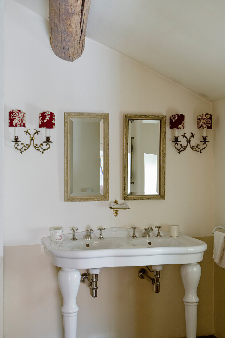 Bathroom with two mirrors and vintage-style candlesticks