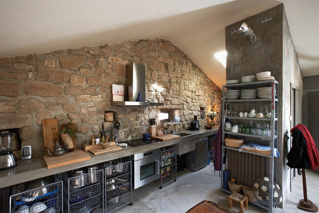 Modern kitchen counter against stone wall in attic room