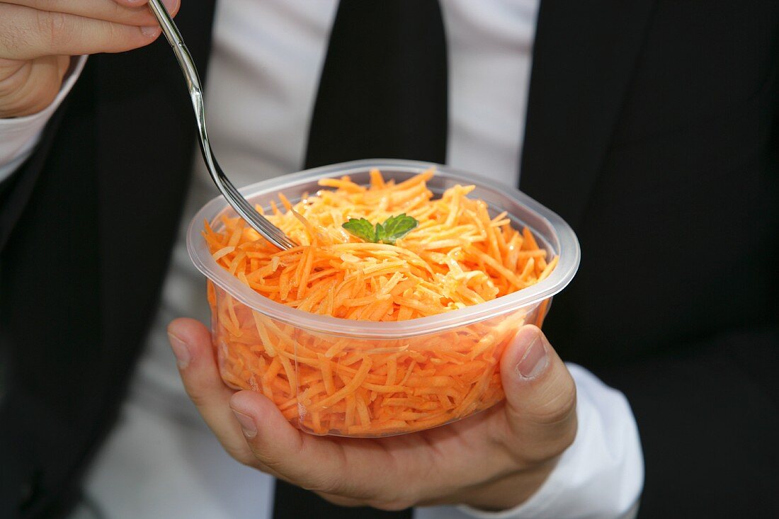A man eating grated carrots