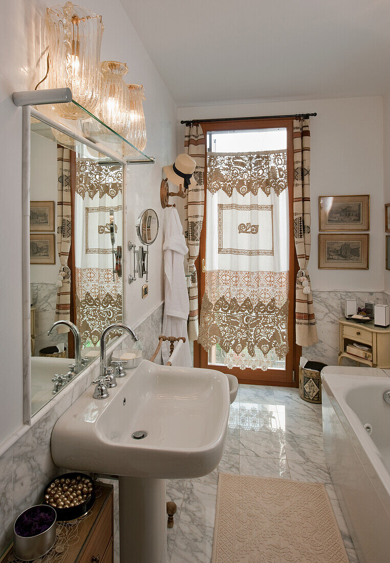 Bathroom with lace curtains and tile floor