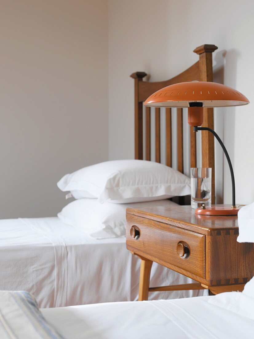 Bedside table with retro lamp between two single beds