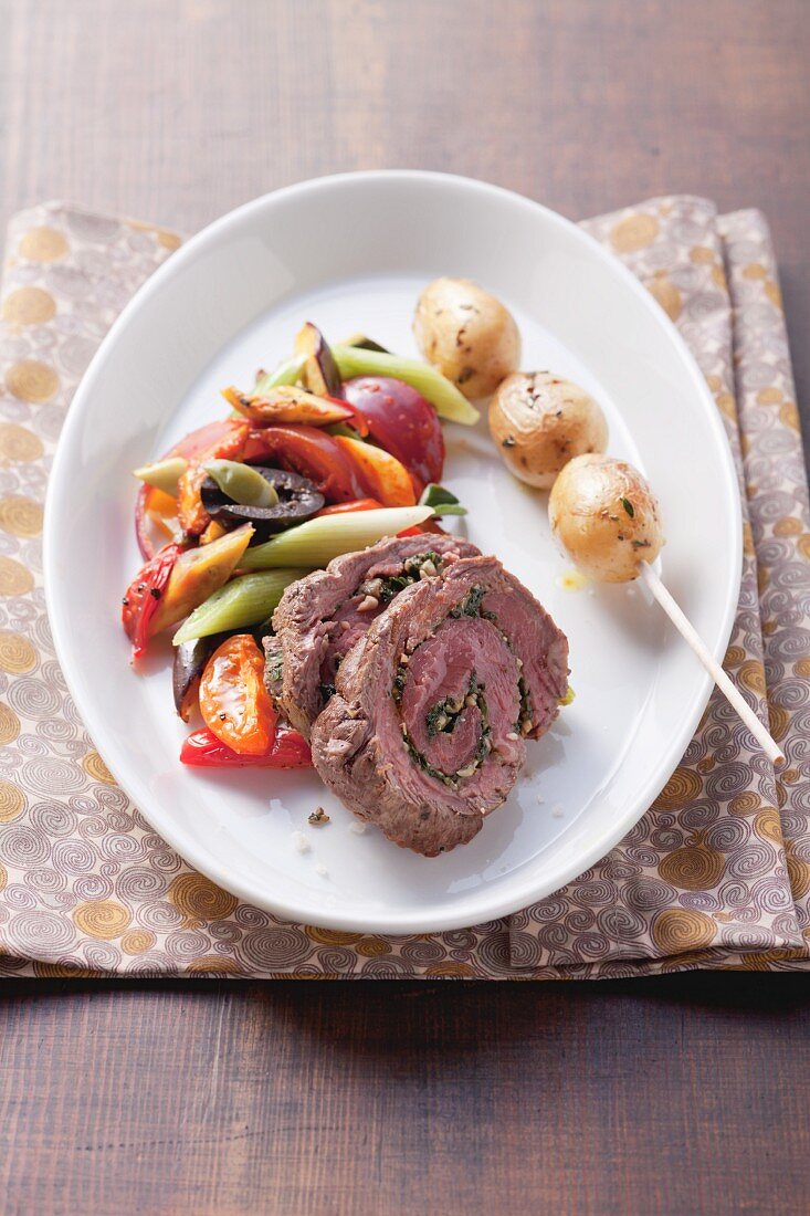 Beef and herb roulades with potato skewers and mixed vegetables