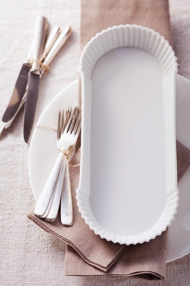 A place setting with a bunch of forks and a bunch of knifes