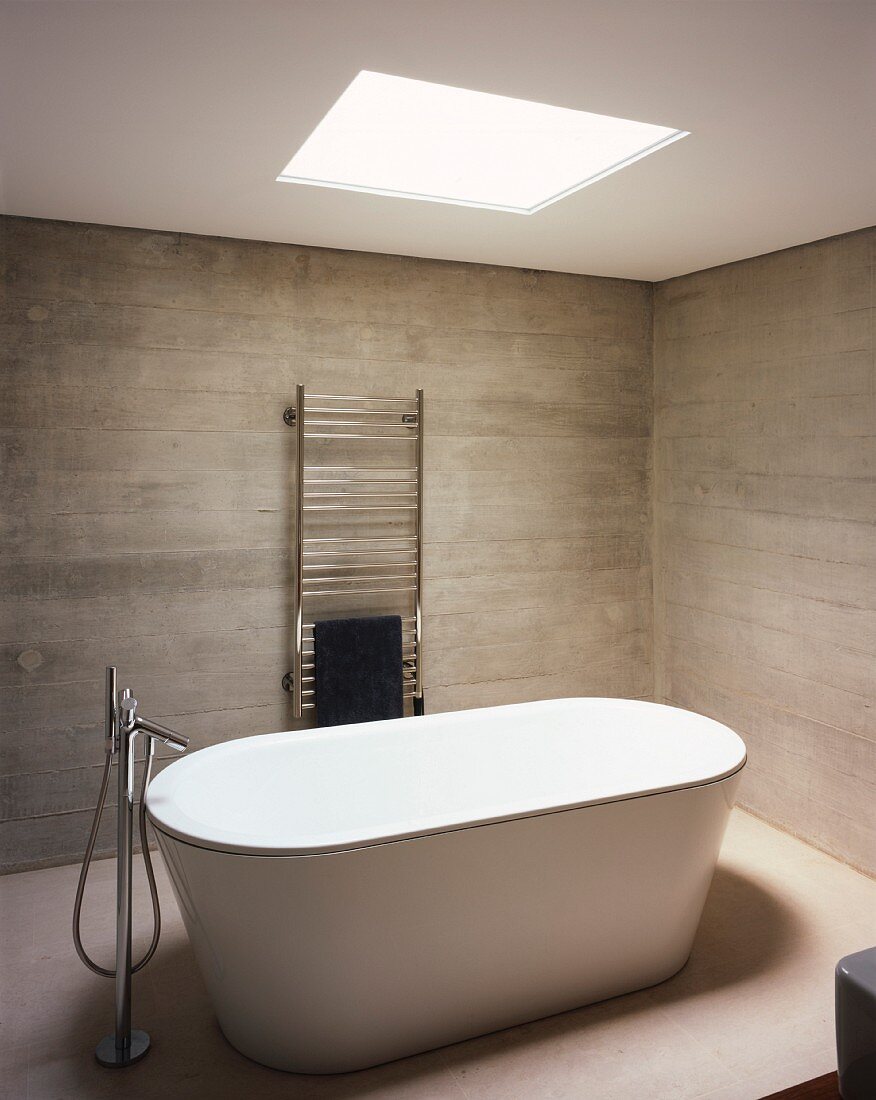 Frei stehende Badewanne in einem minimalistisch eingerichteten Badezimmer