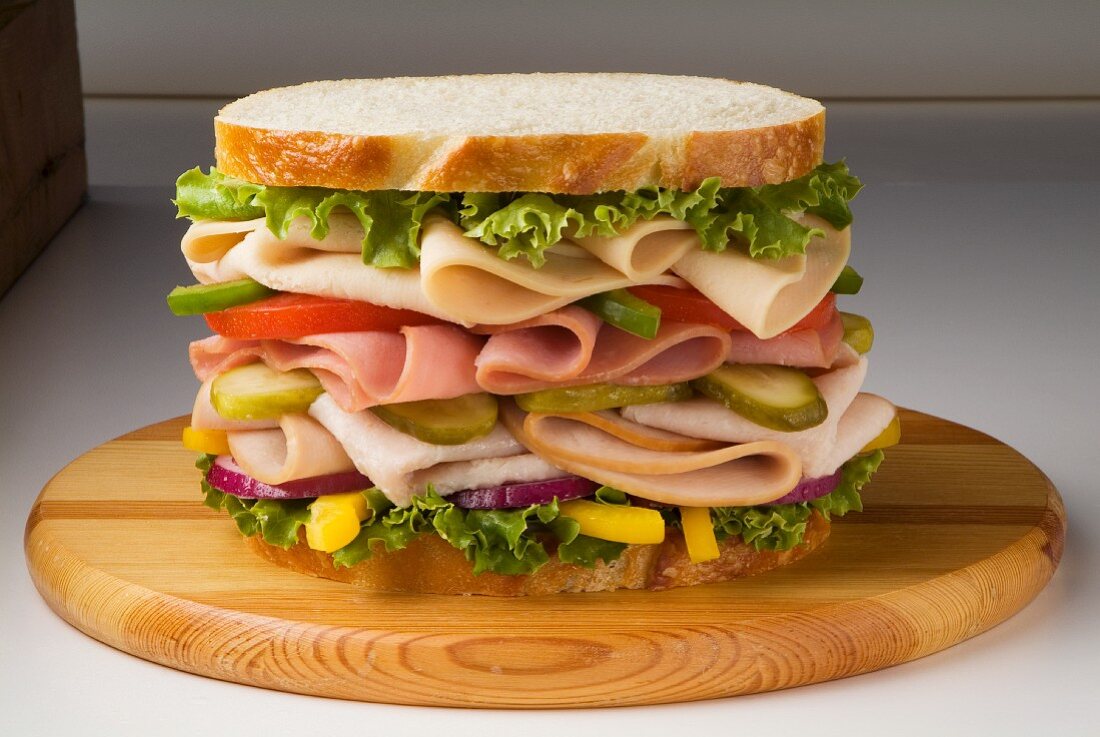 Large Chicken, Ham and Turkey Sandwich with Veggies on White Bread