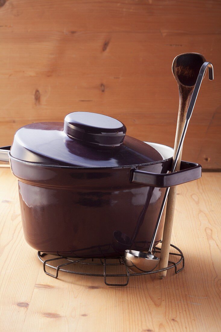 A cooking pot, a wooden spoon and a ladle