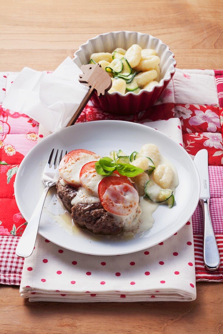 Minced meat steaks topped with mozzarella and tomatoes