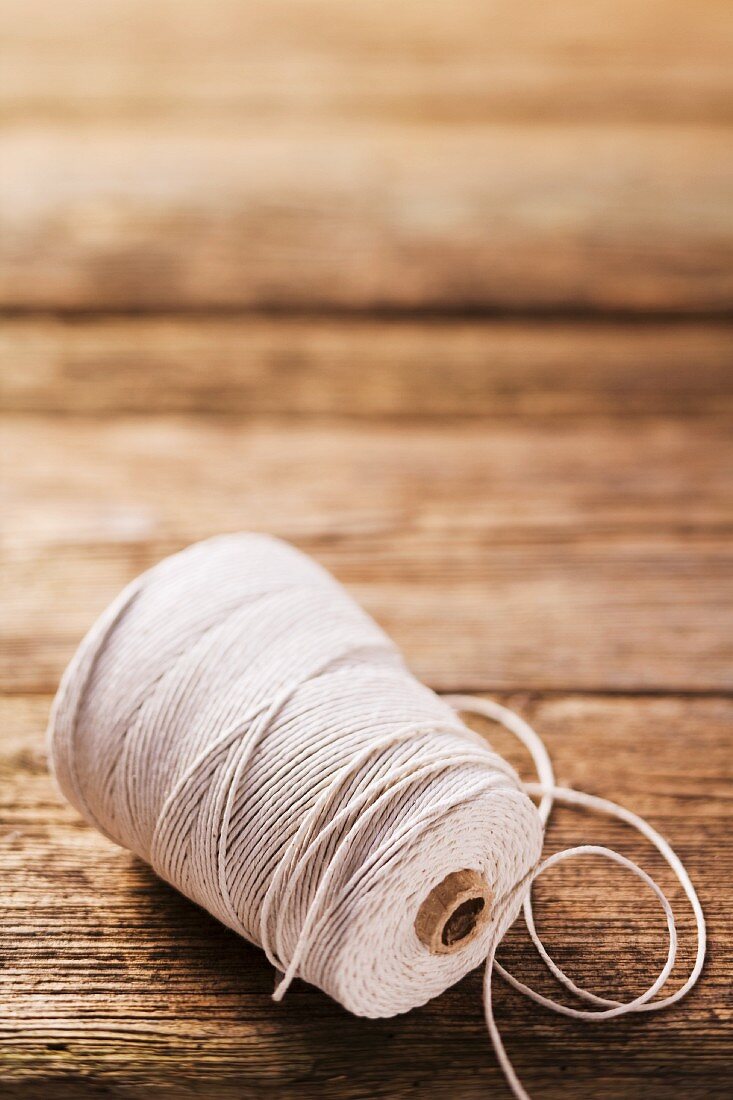 A roll kitchen twine on a wooden surface