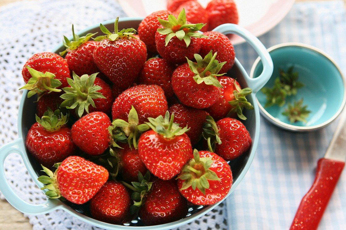 Strawberries in a colander on a crocheted doily