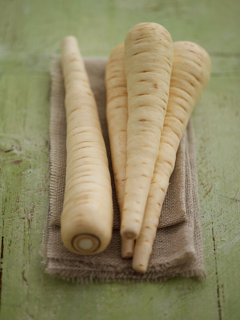 Four parsnips on a linen cloth