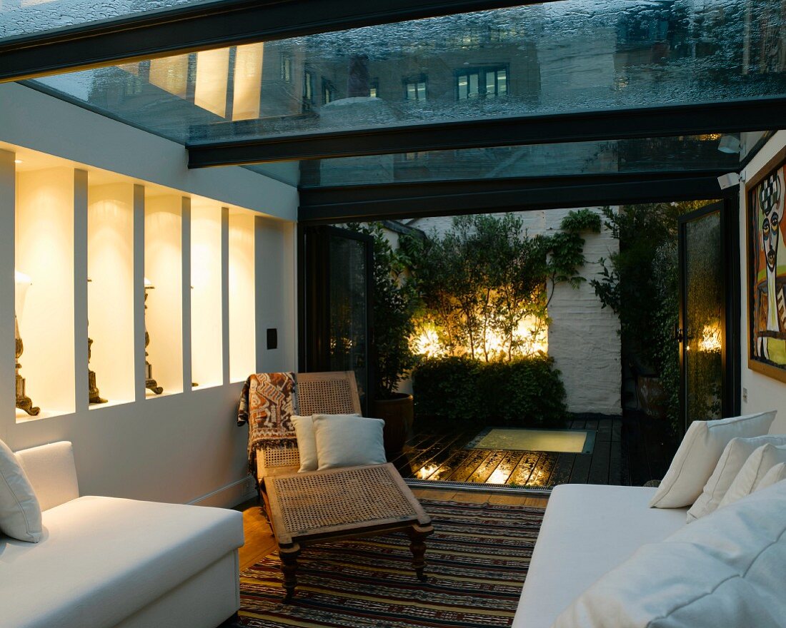 Living room with white sofas and antique couch in modern conservatory