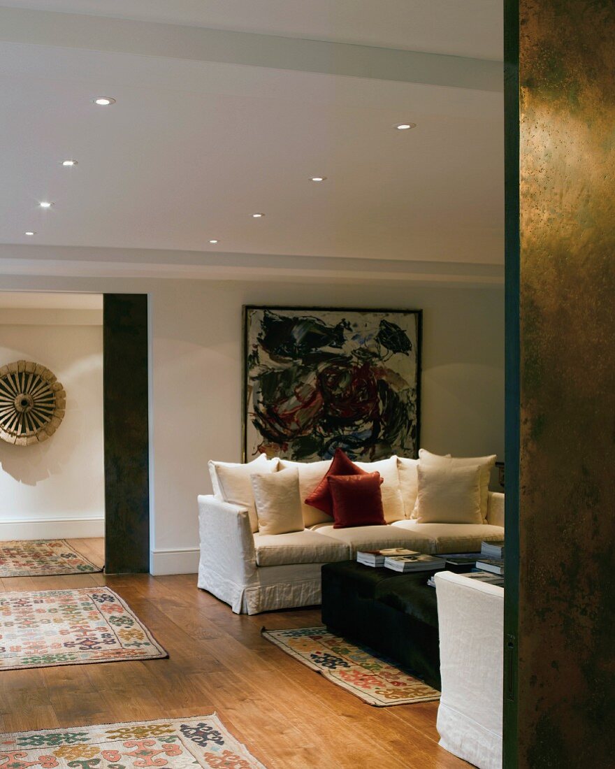 Classic living room with scatter cushions on sofa and rugs on wooden floor