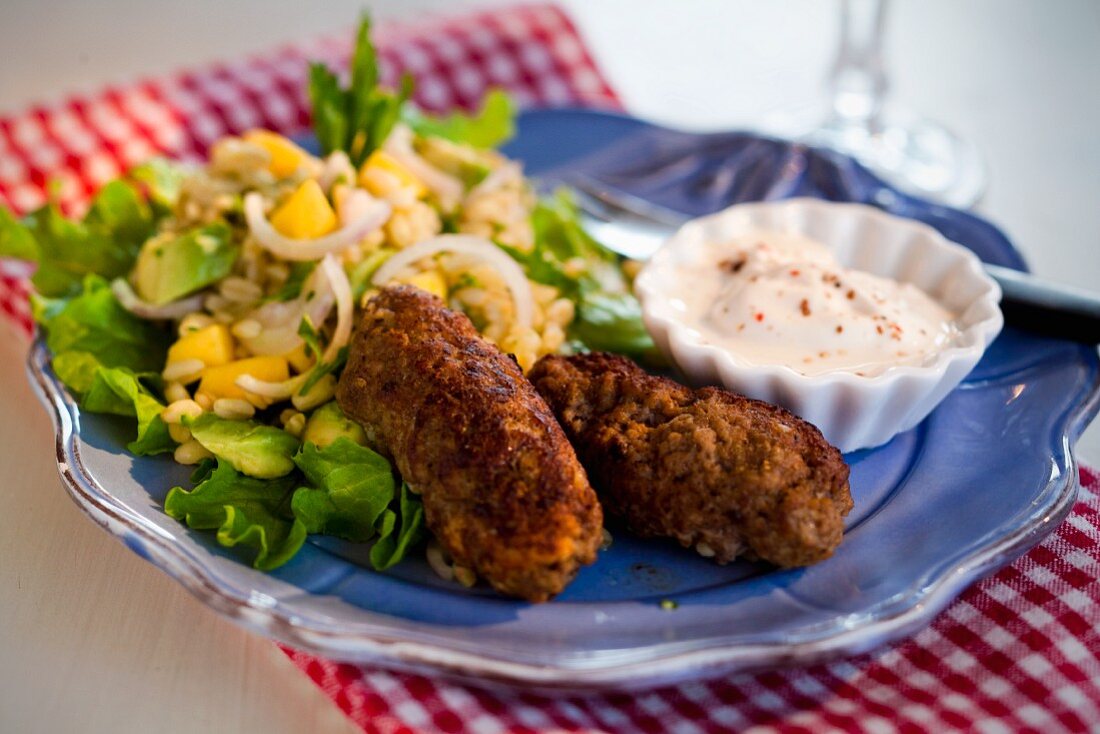 Mincemeat rolls with mango and avocado salad and sour cream dip