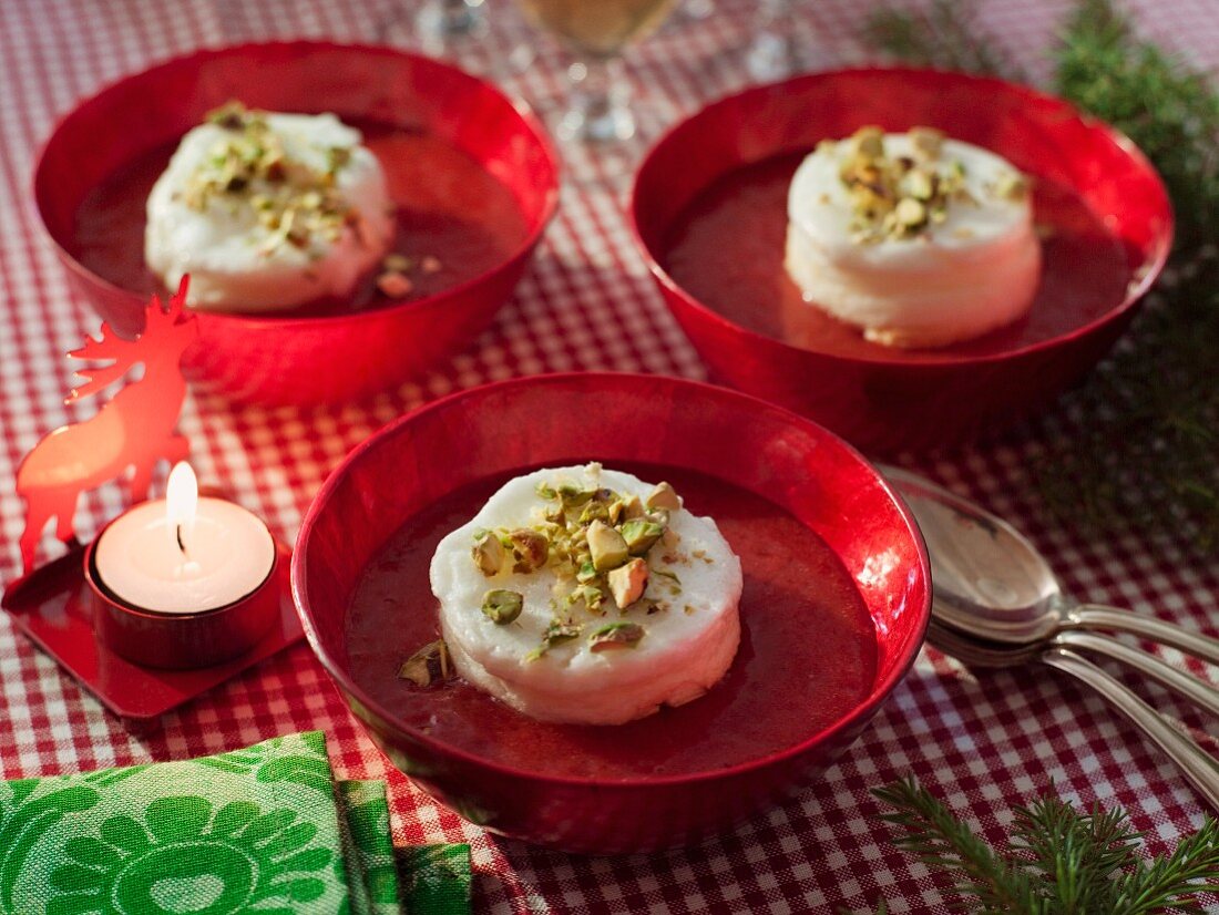 Vanilla dessert with pistachios on strawberry sauce