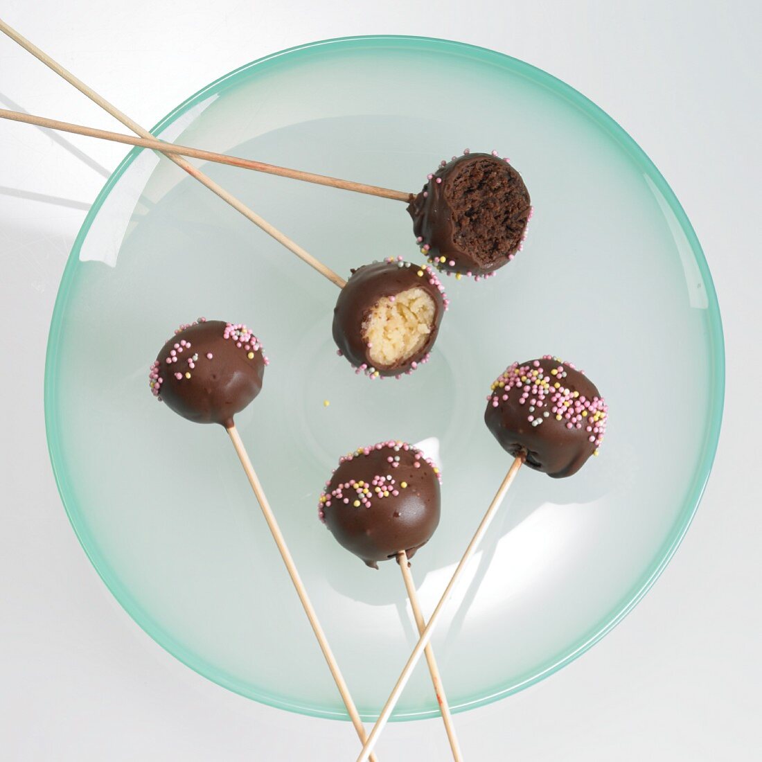 Cake Pops mit Schokoglasur und Zuckerperlen, angebissen