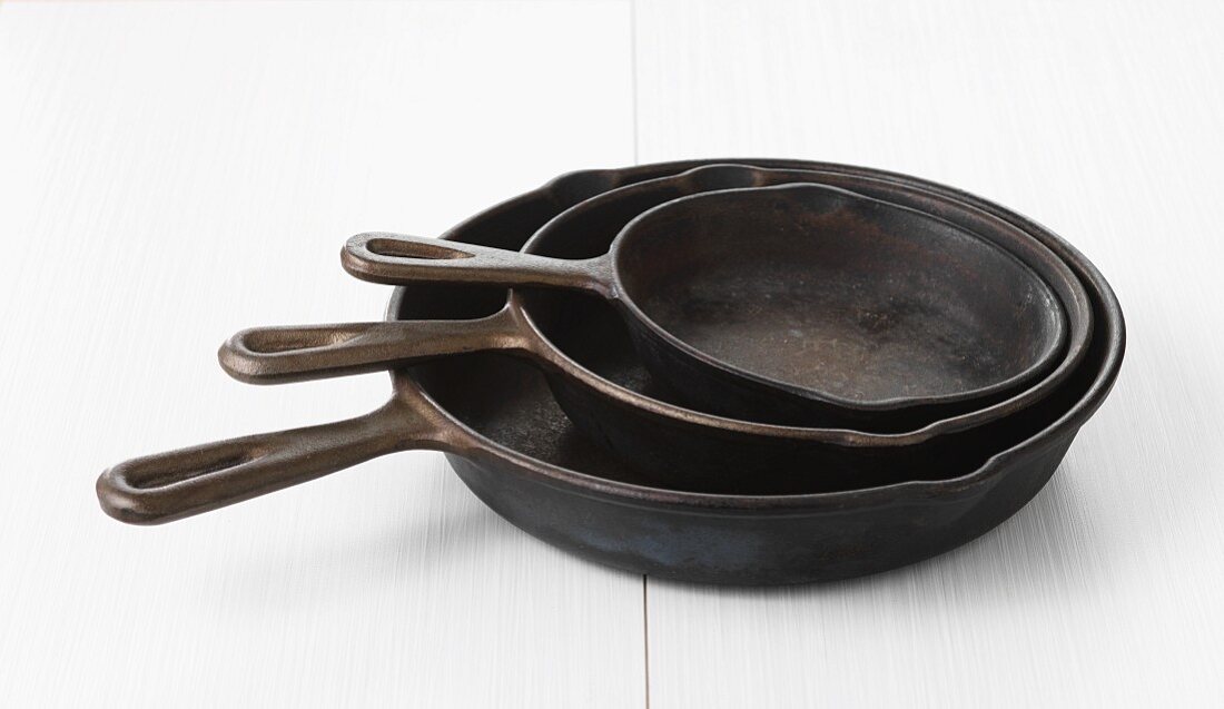 Three iron pans in different sizes