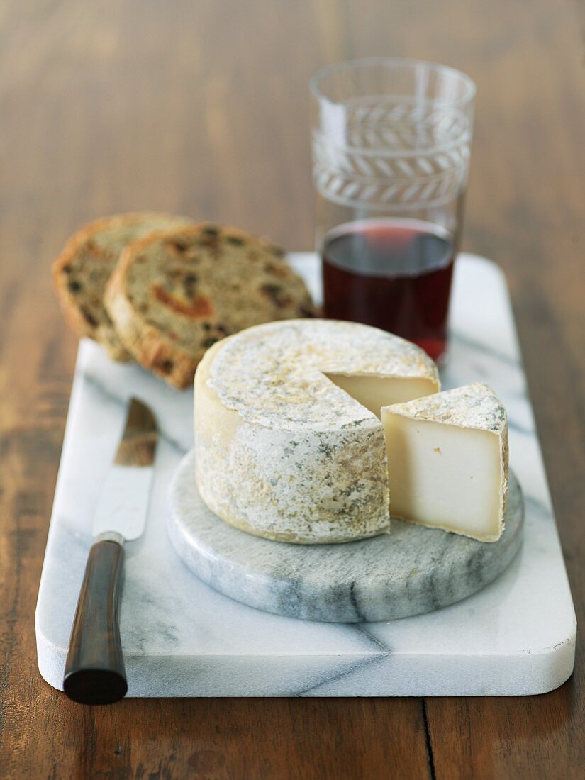 Aged Goat Cheese with Fruit and Nut Bread and Red Wine on Marble