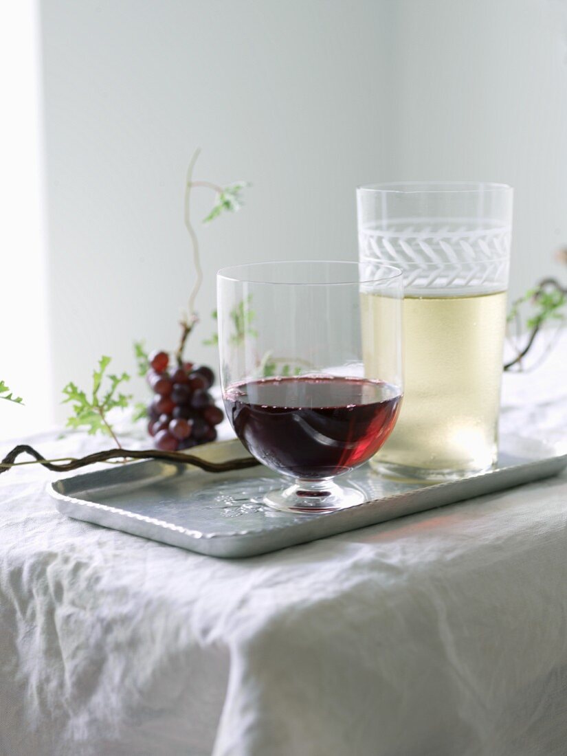 Glas Rotwein und Glas Weißwein auf Tablett